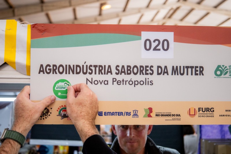A foto mostra uma pessoa colando um selo