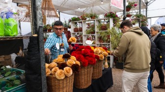 Na imagem, expositor em banca de flores da Expointer atende o p&uacute;blico