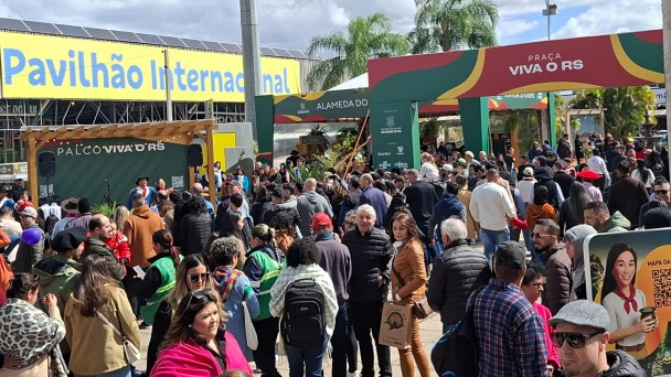 Foto mostra um corredor externo do parque lotado de pessoas circulando pela feira.