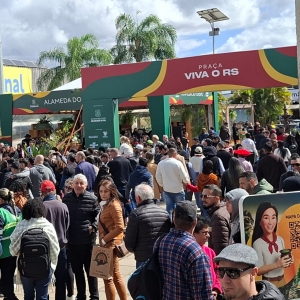 Foto mostra um corredor externo do parque lotado de pessoas circulando pela feira.