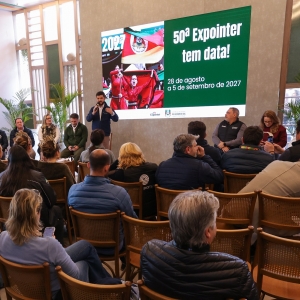 Foto mostra secret&aacute;rio falando durante a coletiva, diante da plateia. Ele est&aacute; em p&eacute; em frente aos participantes, que est&atilde;o sentados. Ao fundo, uma tela com a apresenta&ccedil;&atilde;o.